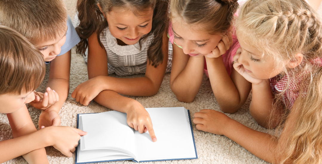 Fem barn som leser i en bok sammen