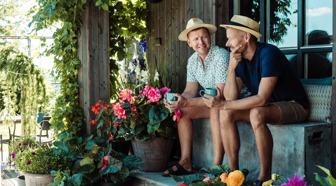 Erik Schjerven og Anders Røyneberg sitter på en benk i sin hage
