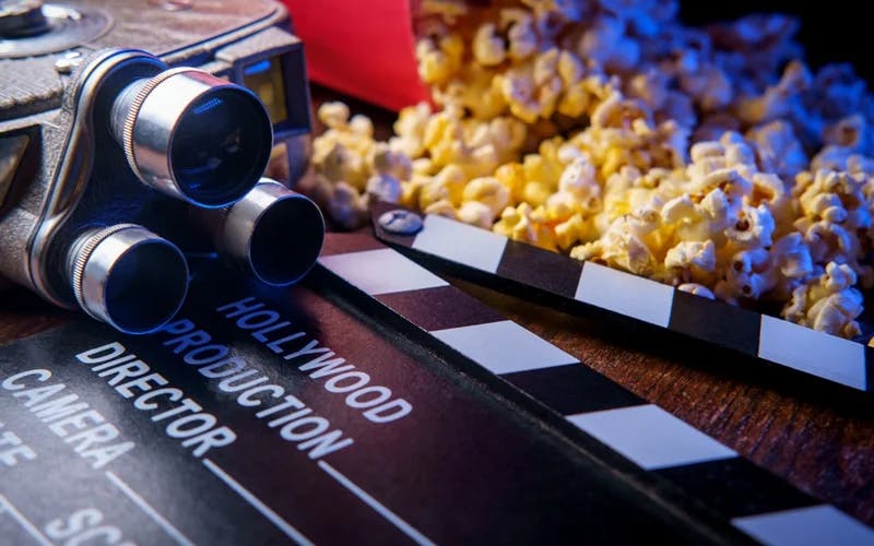 Et illustrasjonsbilde av et filmkamera og popcorn